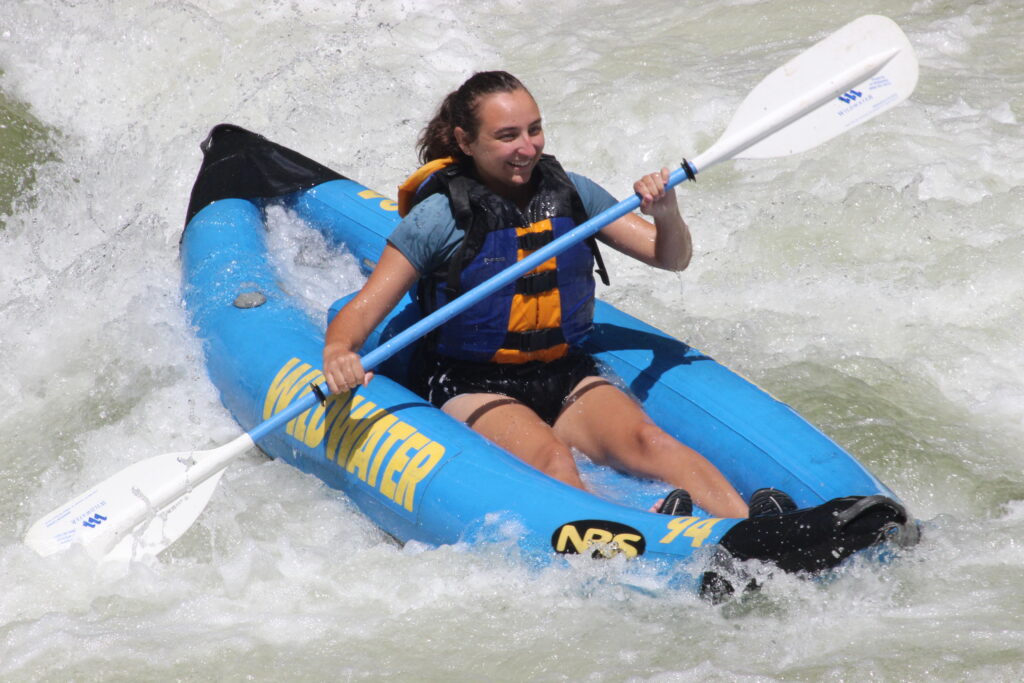 a girl paddling an inflatable kayak on the Nantahala River