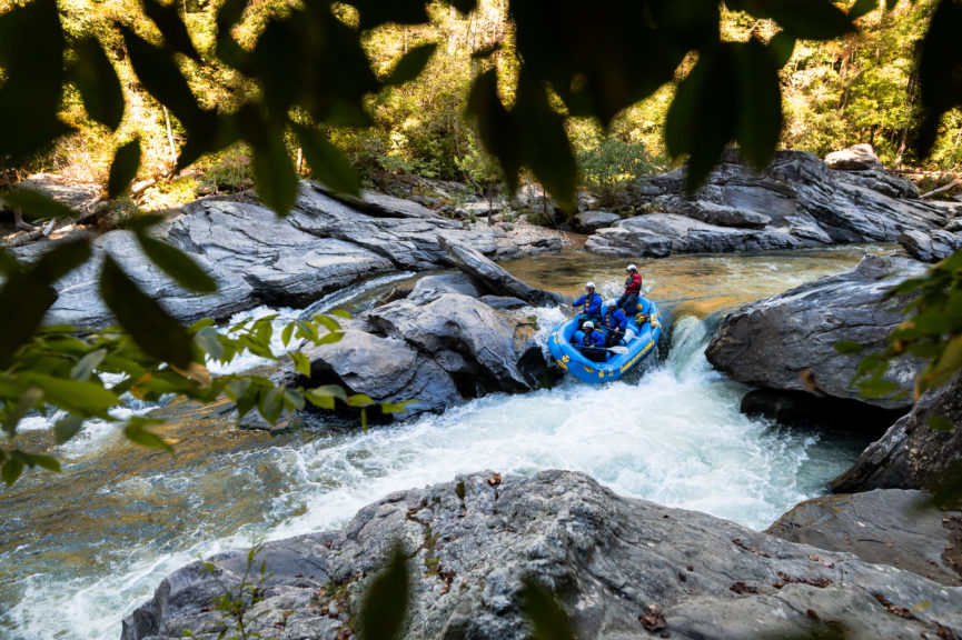 A raft filled with people whitewater rafting the Chattooga river in Georgia